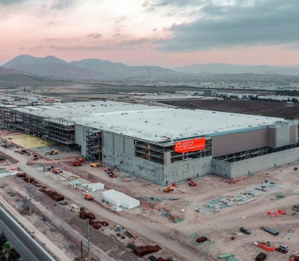 Aerial view of a large Clayco building under construction at dusk