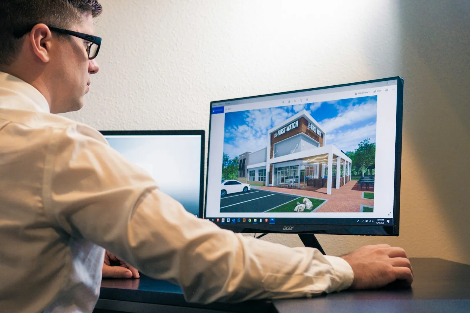 Construction estimator reviewing a building rendering on a computer monitor